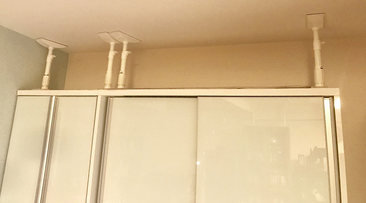 ▲大きな家具は上に突っ張り棒、下にストッパーをつければ安全。