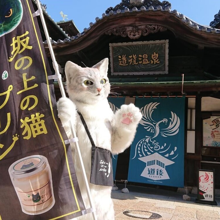 道後温泉の前でのぼりを持つミクちゃん
画像提供：坂の上の猫