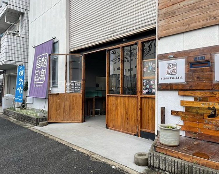 木の外装とのれんが目を引く外観。駐車場も完備