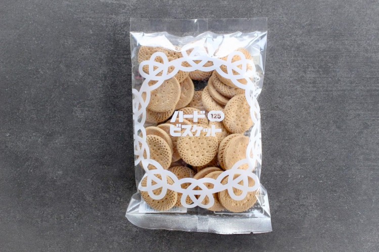 「１２５ｇハードビスケット」。なかのお菓子が見える透明のパッケージを採用。安心と一緒にお菓子を届けている