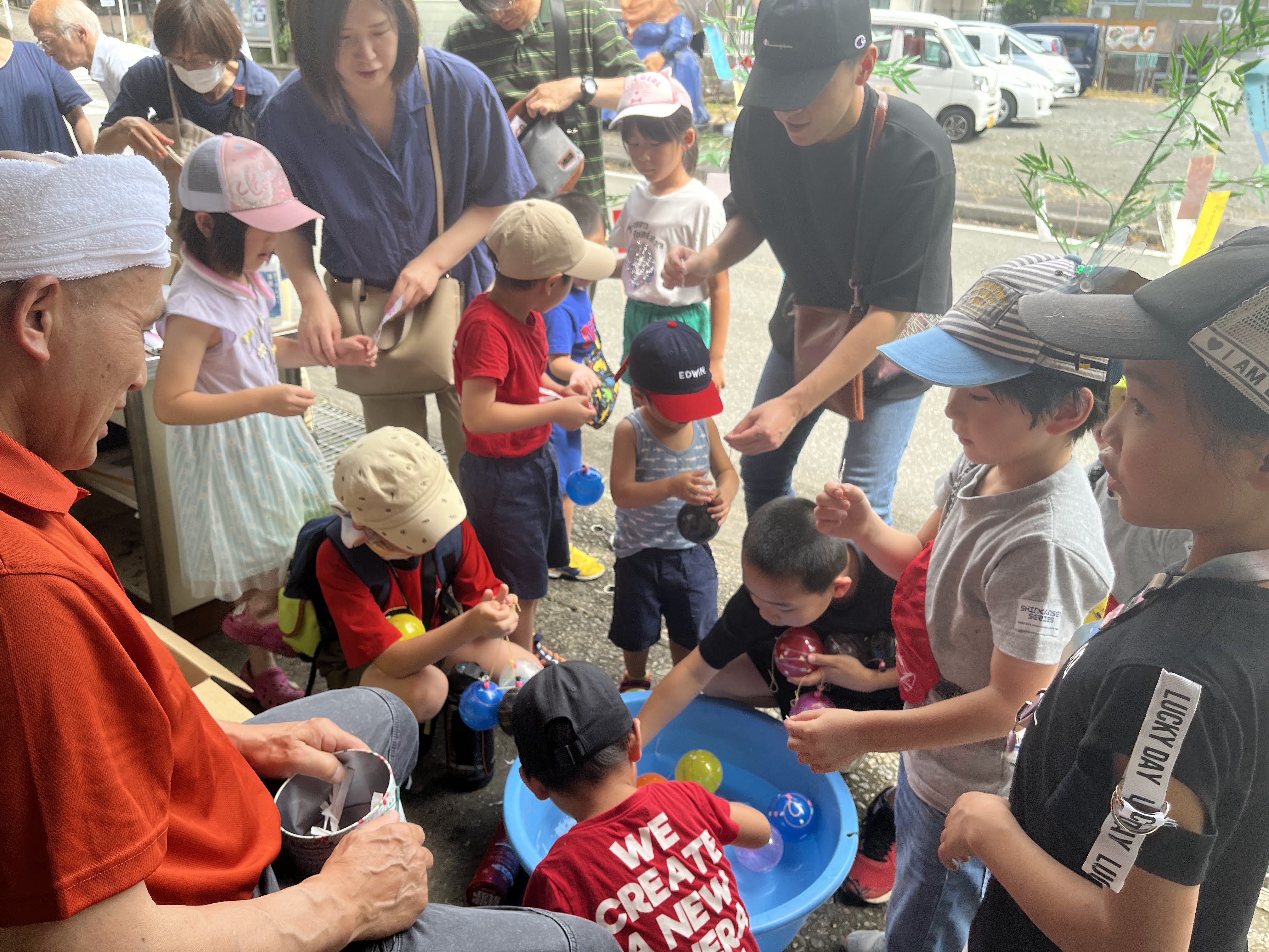 毎年7月7日頃に行われる、七夕祭りのヨーヨーすくいに夢中になる子どもたち