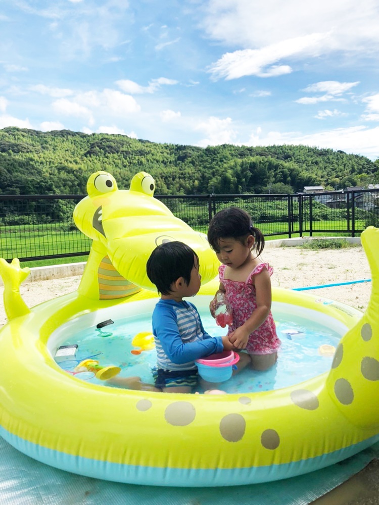 自宅の庭でプール遊びを楽しむ子どもたち。奥に見える林ではホタル観賞ができるそうです。